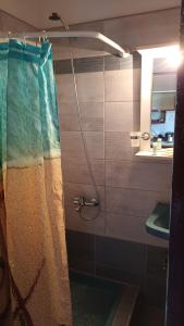 a bathroom with a shower curtain and a sink at Tasia Studios in Perivolion