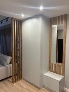 um quarto com uma parede branca com uma cama e um espelho em Apartament Kościuszki 47m44 na Cracóvia