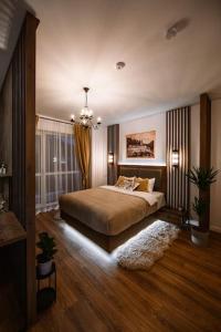 a bedroom with a bed and a chandelier at Eliss Studio Sinaia in Sinaia