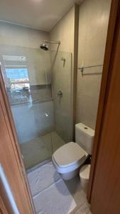 a bathroom with a white toilet and a shower at Flats, Apartamentos e Bangalôs na Praia dos Carneiros, ao lado da Igrejinha de São Benedito in Praia dos Carneiros