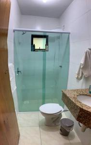 a bathroom with a shower and a toilet and a sink at Pousada Passig in Guaramirim +56 photos