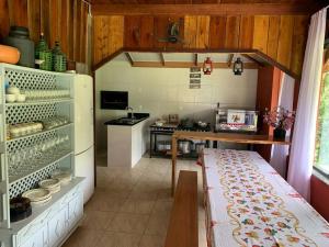 a small kitchen with a table and a stove at Pousada Passig in Guaramirim