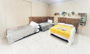 a room with two beds and a couch at Loft Familiar BR-Aeroporto 1 in Uberlândia