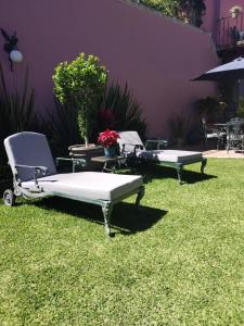 zwei Stühle und ein Bett im Gras in der Unterkunft Villa Orbayu B&B Boutique in Cuernavaca