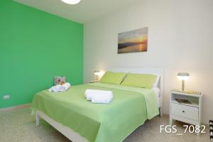 um quarto verde com uma cama e uma mesa de cabeceira em La Coccinella Sorrento em Sorrento