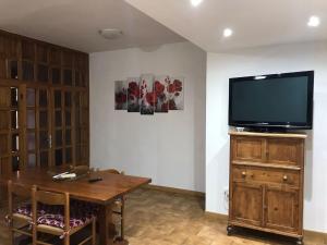 a living room with a tv and a wooden table at Casa La Quercia in Chiusi della Verna