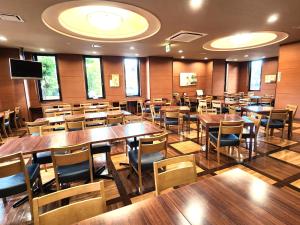 Hotel Route-Inn Dai-ni Kameyama Inter في كامياما: مطعم فيه طاولات وكراسي في الغرفة
