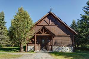 a log cabin with a gambrel roof at Chalets Royal Laurentien in Saint-Faustin