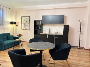 a living room with a table and chairs and a kitchen at Quartier Victoria - Exklusives Souterrain-Studio am Goethepark mit Küche in Weimar