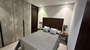 1 dormitorio con 1 cama con cabecero de madera en Dpto nuevo en Chapultepec, en Guadalajara