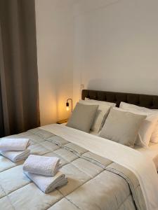 ein großes weißes Bett mit zwei Handtüchern darauf in der Unterkunft Apartment near Athens Airport, Rafina Port and Sea in Artemida