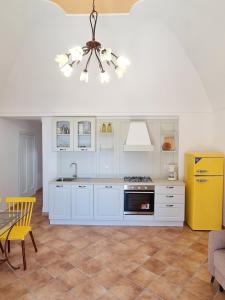 een keuken met witte kasten en een gele koelkast bij Casa Monticello in Positano