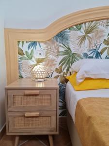 1 dormitorio con 1 cama y mesita de noche con papel pintado tropical en Casa Monticello, en Positano