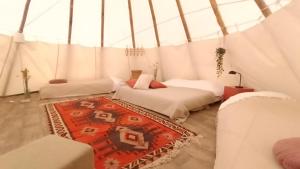 a room with two beds and a rug in a tent at Wigwam in Roodhuis