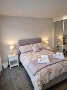 a bedroom with a large bed with two towels on it at Begonia Cottage in Briston