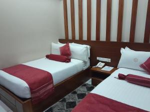 a hotel room with two beds with red pillows at HOTEL MDOPE MBEYA in Mbeya