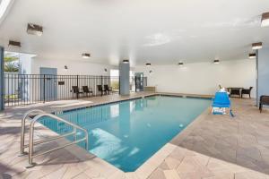 Comfort Suites West Jacksonville في جاكسونفيل: مسبح بمياه زرقاء في مبنى