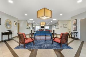 Comfort Suites West Jacksonville في جاكسونفيل: غرفة معيشة مع أريكة وكرسيين