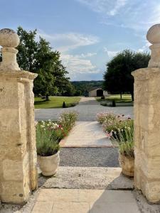 uma entrada para uma casa com dois potes de flores em Chateau Masburel em Fougueyrolles