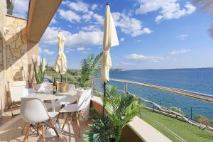 a balcony with a table and chairs and the ocean at Apartment Jasmin - Amazing Seaview Maisonette with direct beach access in Rtina