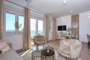 a living room with a couch and two chairs at Apartment Jasmin - Amazing Seaview Maisonette with direct beach access in Rtina