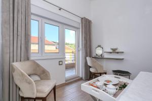 a living room with a table and chairs and a window at Apartment Jasmin - Amazing Seaview Maisonette with direct beach access in Rtina