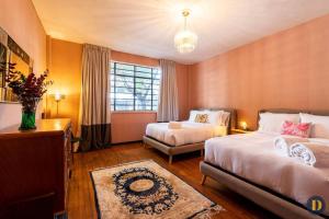 墨西哥城的住宿－102 Amplio y elegante estilo Art Déco，酒店客房设有两张床和窗户。