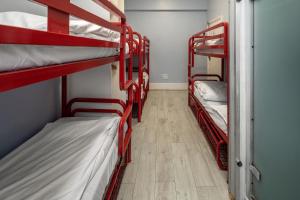 Pokój z 3 łóżkami piętrowymi i drewnianą podłogą w obiekcie Astor Victoria Hostel w Londynie