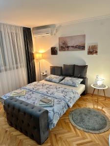 a bedroom with a large bed and a couch at Apartment PEACE in Trebinje