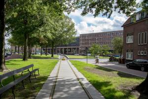 a sidewalk in a city with a person riding a bike at Bed & Breakfast - Gallery 't Speelhuys in Breda