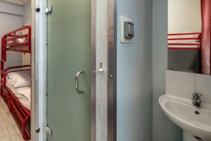 La salle de bains est pourvue de toilettes et d'un lavabo. dans l'établissement Astor Victoria Hostel, à Londres