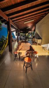 a room with a table and chairs and a hammock at Casa Carandá in Campo Grande