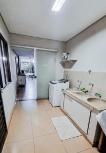 a kitchen with two sinks and a dishwasher at Casa Carandá in Campo Grande
