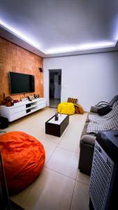 a living room with a couch and a flat screen tv at Casa Carandá in Campo Grande