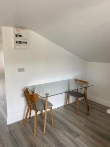 una mesa de cristal y 2 sillas en una habitación en Gloun Cross Lodge, en Dunmanway