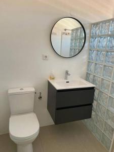 a bathroom with a white toilet and a mirror at Villa Favvidae ~ Close to Beach in Jan Thiel