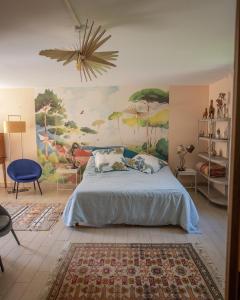 - une chambre avec un lit et une peinture murale dans l'établissement La Sorellerie, à Saint-Avertin