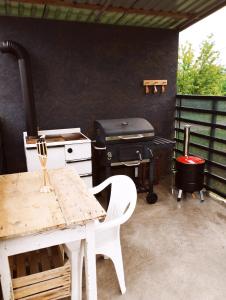 a patio with a table and a grill at Lavender Vendégház Kicsi falu nagy szívvel varázslatos légkörrel in Golop