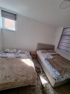 1 dormitorio con 2 camas y ventana en Markov Konak, en Foča