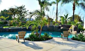 two chairs sitting next to a swimming pool at Destination #03 in Fullerton