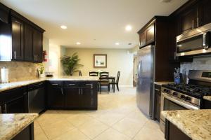 uma cozinha com armários de madeira escura e electrodomésticos de aço inoxidável em Destination #23 em Anaheim