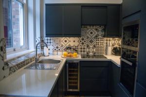 a kitchen with black cabinets and a sink at Flat in Nottingham City Centre in Nottingham