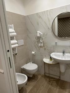 La salle de bains blanche est pourvue de toilettes et d'un lavabo. dans l'établissement NLM Boutique Suites, à Rome