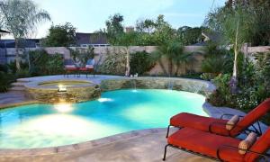 una piscina con una fuente y un banco en un patio en Destination #23, en Anaheim