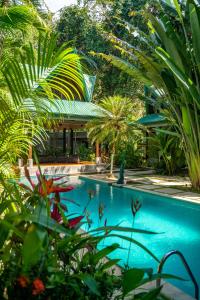 una piscina con palmeras y un edificio en Jade Nosara, en Nosara