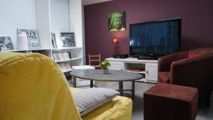 ein Wohnzimmer mit Fernseher und Tisch in der Unterkunft LES BOHEMIELLES 4**** Cottage MARTIN in Cartelègue