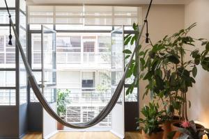 a hammock in a room with a large window at Mr W Photographers Choice Condesa Balcony in Mexico City