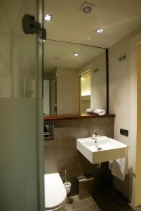 a bathroom with a sink and a toilet and a mirror at Hotel La Fonda Moreno in Morella