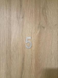 Una puerta de madera con el número cinco. en So in Sopot Station, en Sopot