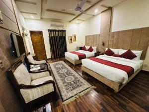 een hotelkamer met 2 bedden en een stoel bij Shelton’s Rezidor Lahore in Lahore